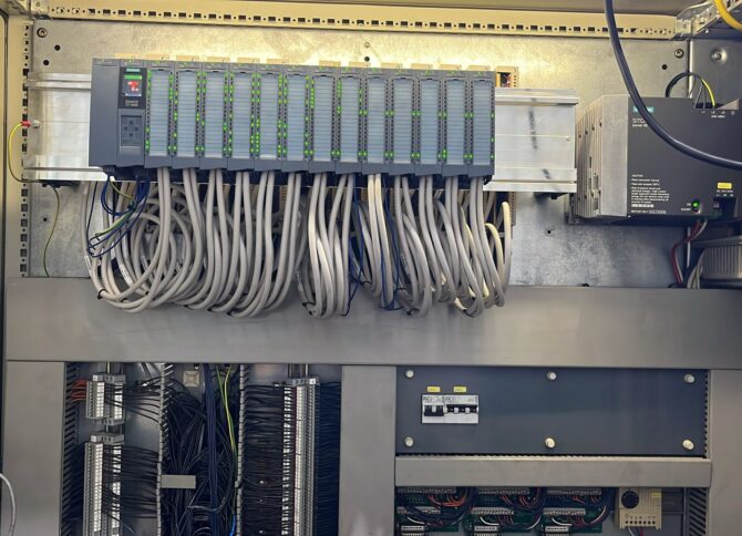 Besturingskast waarin een oude Siemens S5 PLC succesvol is vervangen door een nieuwe Siemens S7-1500 PLC met I/O-modules en voeding.