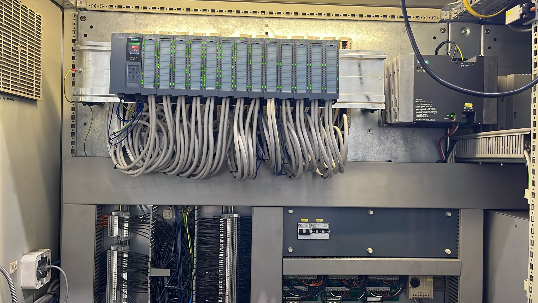 Besturingskast waarin een oude Siemens S5 PLC succesvol is vervangen door een nieuwe Siemens S7-1500 PLC met I/O-modules en voeding.